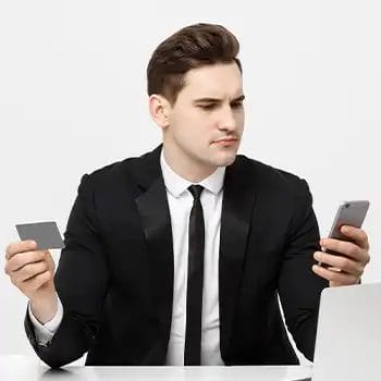 A man wearing business attire looking through his phone