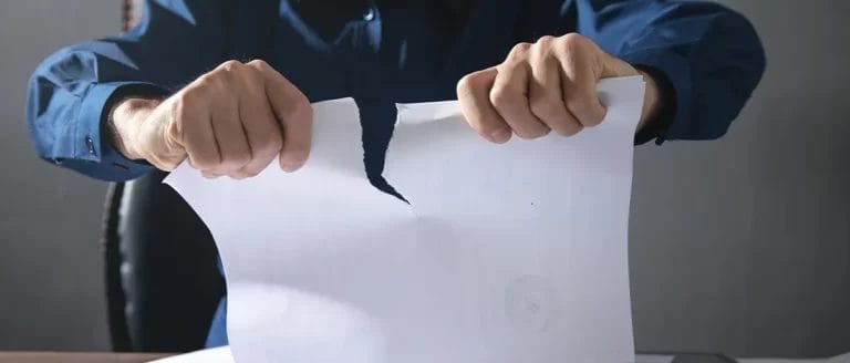 A man tearing a paper after a company was dissolved