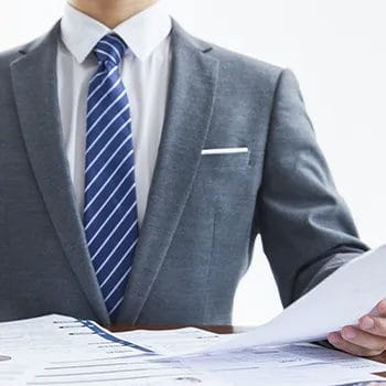 Man in corporate attire reviewing paper document