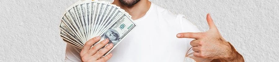A man holding money bills and deciding how much money he will need for an LLC