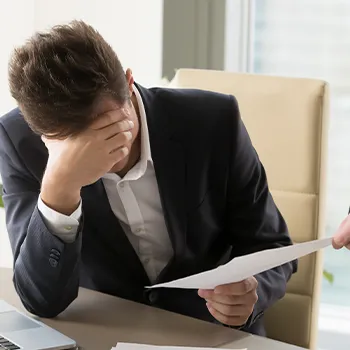 Stressed man in suit receiving more paper works