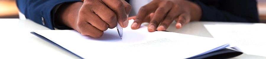 Man in suit writing on paper