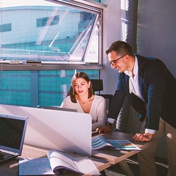 Two colleagues discussing with a laptop