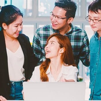 Office members gathered around a laptop having a discussion about single member and multiple member LLCs
