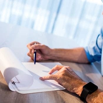 A man writing on a paper about LLC