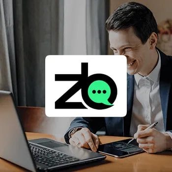 A business man using a laptop as a background for ZenBusiness logo
