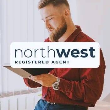 Northwest Registered Agent Service logo with an office worker standing up looking at a book in the background