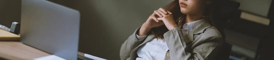 An office woman thinking about the advantages of working with a registered agent service in New Hampshire