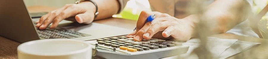 A man using a calculator to compute the LLC cost in Maine