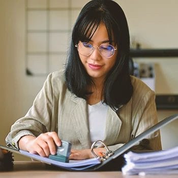 An office worker doing paperwork on an annual report initial list