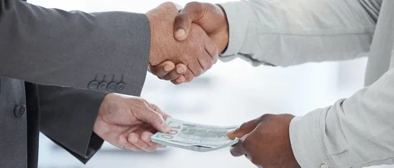 Shaking hands with someone while handing money for an LLC in Rhode Island