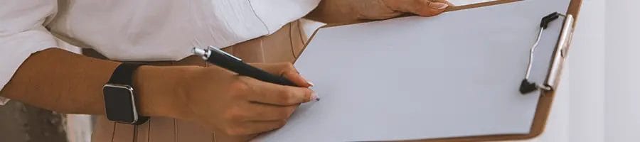 A person writing down on a clipboard